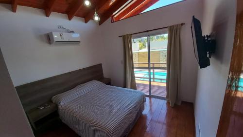 科隆Solar de Artalaz的一间卧室设有一张床和一个带游泳池的窗户