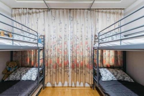首尔Good Stay Itaewon的一间卧室设有两张双层床和窗帘
