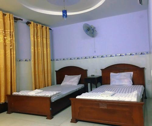 胡志明市Phúc Lộc Thọ Hotel的卧室设有两张单人床,墙上挂有时钟