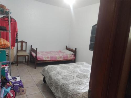 伊图佩瓦Chacara Recanto Paraíso Guacuri 2的一间小卧室,配有两张床和椅子