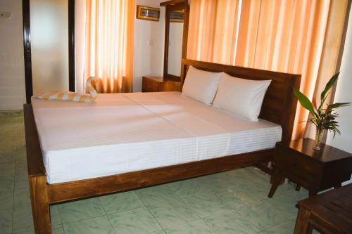 KotmaleVaranda With A View的一间卧室配有一张带白色床单的大床