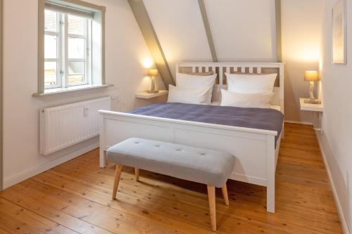 弗伦斯堡Stadthaus Flensburg的卧室配有白色的床和窗户。