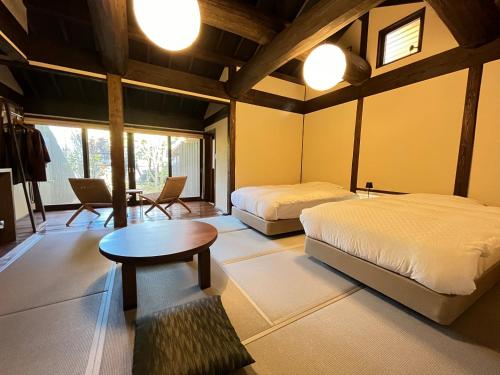 南小国町Kyutei的一间卧室配有两张床和一张桌子