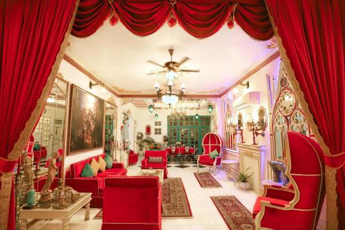 斋浦尔The Royal Hermitage - Best Luxury Boutique Hotel Jaipur的客厅配有红色椅子和红色窗帘