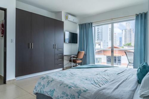 巴拿马城Apartamento en San Francisco的一间卧室设有一张大床和一个大窗户
