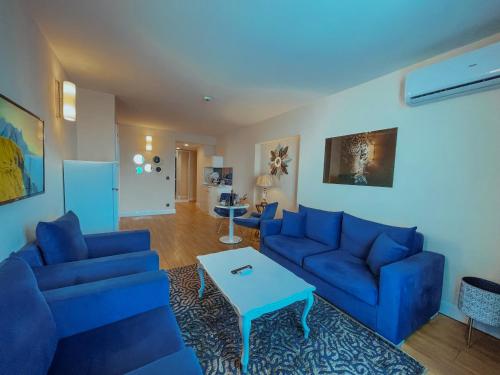 巴统Orbi floor40的客厅配有蓝色的沙发和桌子