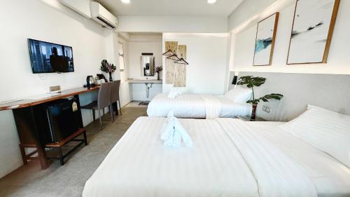 清迈Key酒店@古城中心店的酒店客房配有两张床和一张书桌