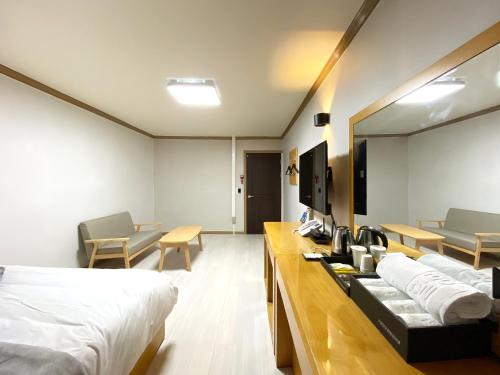 忠州市Suanbo Hot Spring Healing Hotel的酒店客房设有两张床和一张桌子。