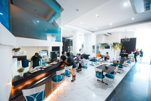 宿务夸特罗码头酒店的餐馆,有坐在桌子和柜台的人