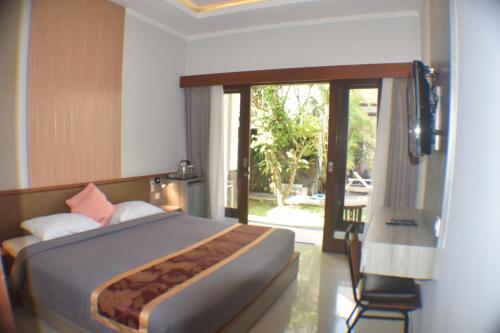 坎古黛比麦都宾馆的一间卧室设有一张床和一个滑动玻璃门