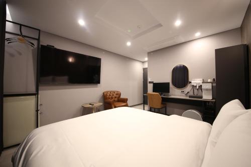 GongjuStay Oneul的一间酒店客房,配有一张白色的床和一张书桌