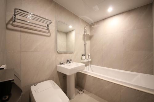 GongjuStay Oneul的浴室配有盥洗盆、卫生间和浴缸。