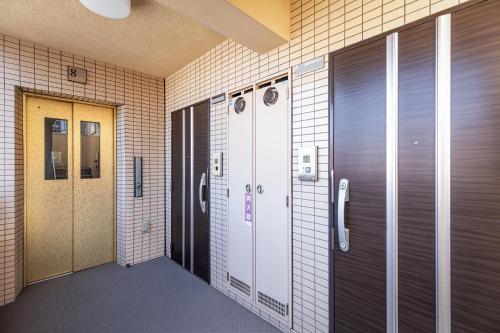 福冈Tenjin Minami San Ban Kan的走廊,带两个储物柜和一扇门的建筑