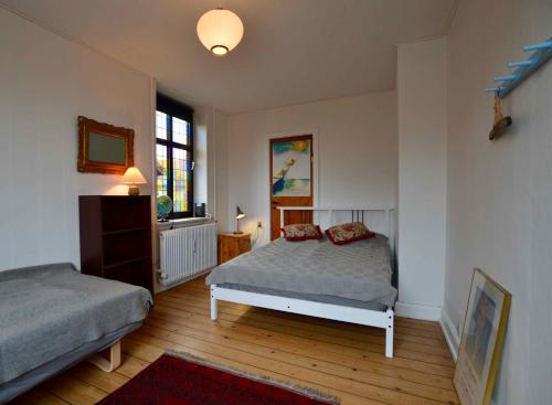 斯泰厄Charmerende Lejlighed I Stege Midtby的一间卧室设有两张床和窗户。