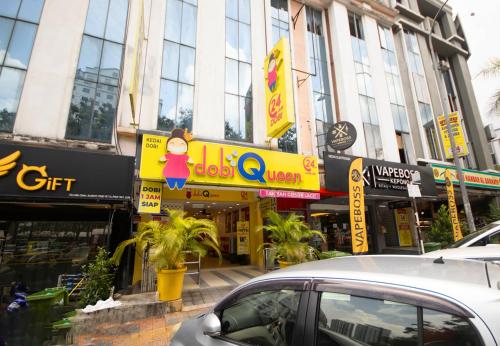 吉隆坡Sun Inns Hotel Kepong near Hospital Sungai Buloh的一条城市街道,前面有汽车停放的建筑