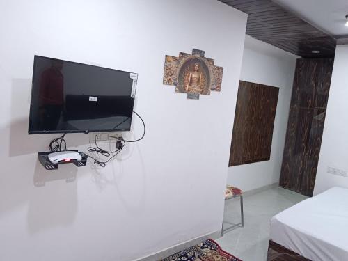 乌代浦Hotel Balaji Residency的一间白色墙壁上配有电视的房间