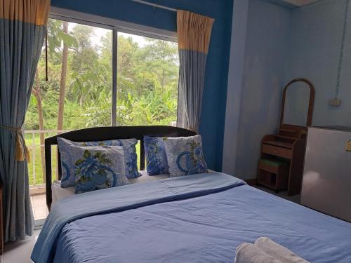 考科博士楼酒店的一间卧室配有一张带蓝色床单的床和一扇窗户。