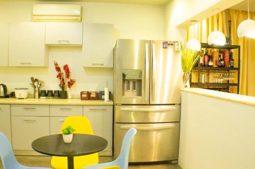 阿克拉3D's Luxury Properties的厨房配有不锈钢冰箱和桌子