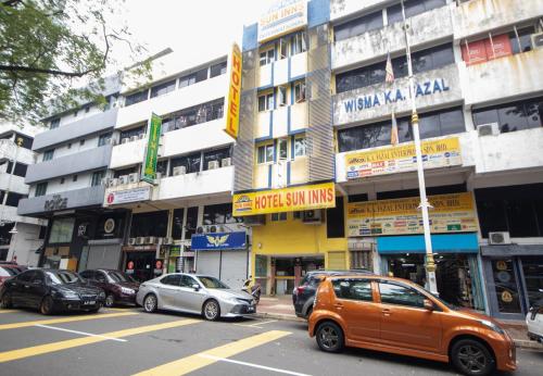 吉隆坡布里克菲尔德中心太阳酒店的停在大楼前的橙色汽车
