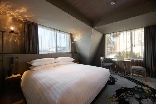 京都THE HOTEL HIGASHIYAMA by Kyoto Tokyu Hotel的卧室配有一张带白色床单和窗户的大床。