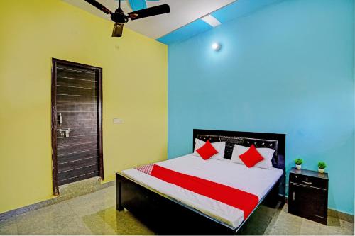 JhājharOYO Flagship Midtown Guesthouse的一间卧室配有红色枕头的床