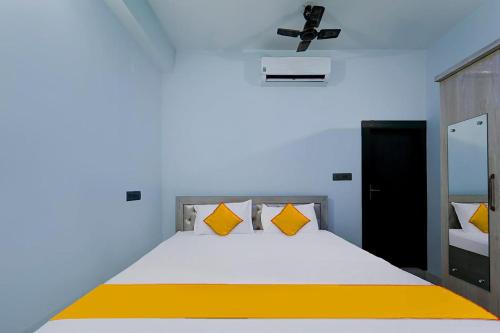 兰奇FabExpress JT Complex的一间卧室配有一张带黄色枕头的大床