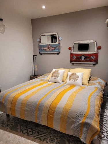弗雷瑞斯Charmant 2 pièces proche Plage的卧室配有一张床,墙上挂有两辆面包车