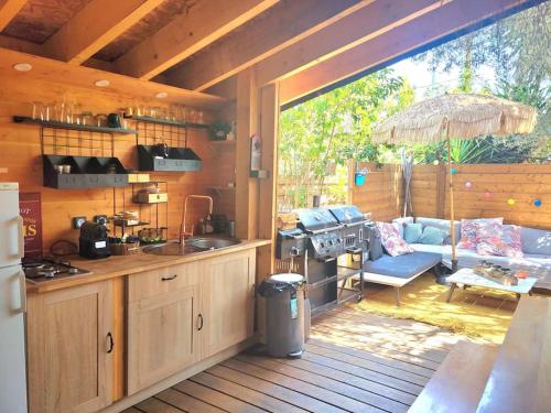 弗雷瑞斯Petit chalet avec terrasse proche plage的房屋内的厨房和客厅