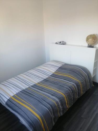 罗纳河畔的图尔农Maison Lydie et Manu的白色房间的床,带条纹毯子