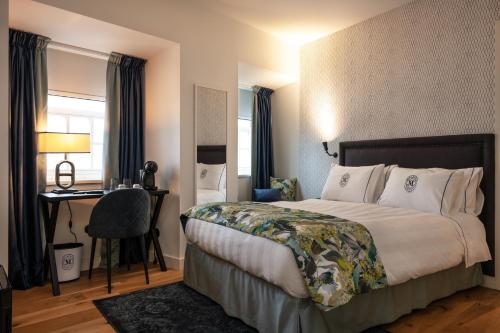菲盖拉-达福什Dona Maria Hotel的配有一张床和一张书桌的酒店客房