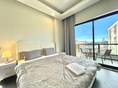 西哈努克SKYVIEW Residence & Apartments Sihanoukville的一间带大床的卧室和一个阳台