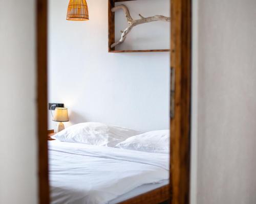 迪弗西Dhiffushi Inn的一间卧室配有一张带白色床单和镜子的床