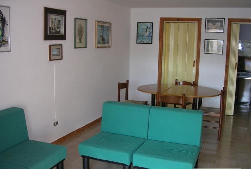 托雷苏达Casa Vacanze Mercurio的客房设有桌子、沙发、桌子和椅子。