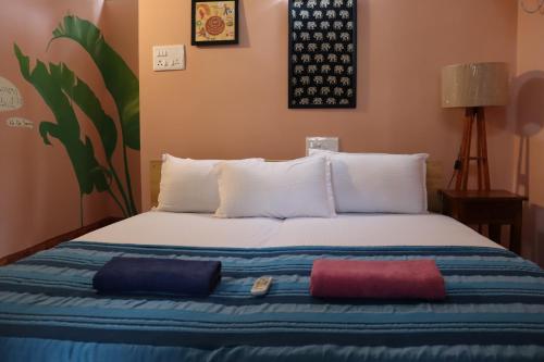 蒂鲁瓦纳马莱Da Mantra House的一张床上有三个枕头的房间
