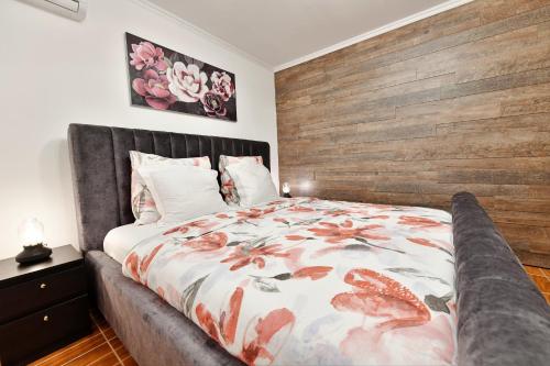 拉科维察Apartments Green Park的一间卧室配有一张大床和木制床头板