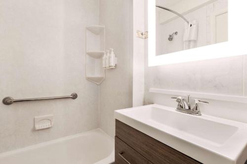大洋城戴斯海滨酒店的白色的浴室设有水槽和浴缸。