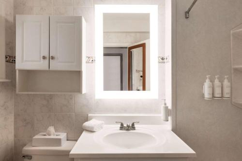 大洋城戴斯海滨酒店的白色的浴室设有水槽和镜子