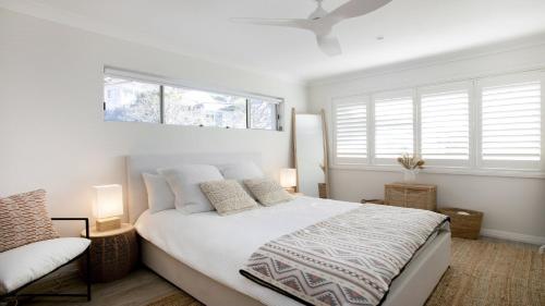 特里格尔Beach Vibes at Terrigal的一间白色卧室,配有床和2个窗户