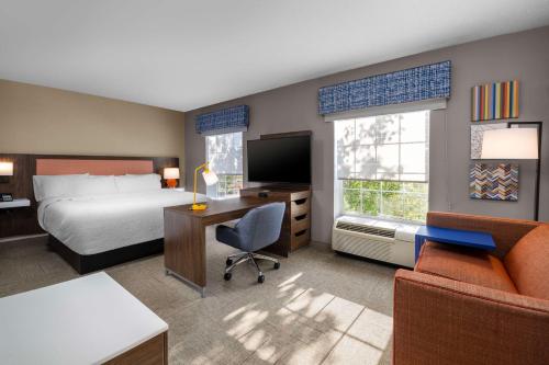 州学院威廉斯堡广场州学院汉普顿套房酒店的酒店客房配有一张床、一张桌子、一张床和一张书桌。
