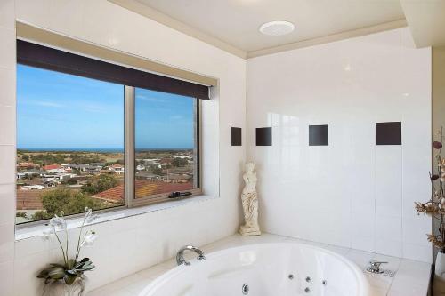 沃纳姆堡拉格伦康福特茵酒店的白色的浴室设有浴缸和窗户。