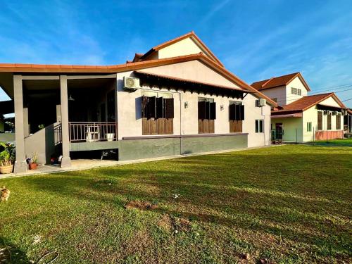 马六甲Rumah Mok Aji Homestay Melaka的前面有绿色草坪的房子