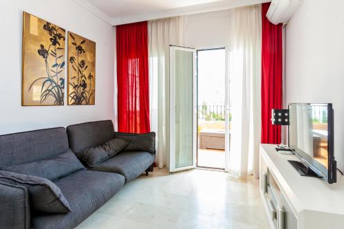 内尔哈Abril Nerja的带沙发和红色窗帘的客厅
