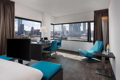 鹿特丹Maashotel Rotterdam Centre的酒店客房设有一张床和一张带显示器的书桌