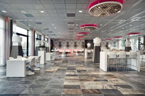 鹿特丹Mainport Hotel Rotterdam, a Hilton Affiliate Hotel的商店内部配有白色的桌椅