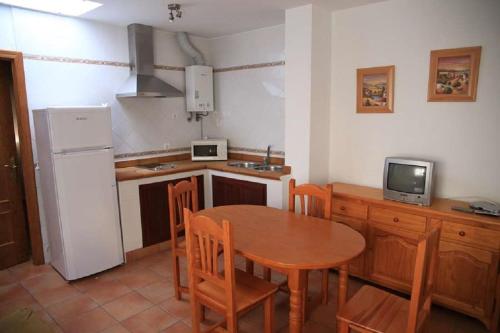 科尼尔-德拉弗龙特拉Apartamento Cadiz Bajo的厨房配有桌椅和冰箱。