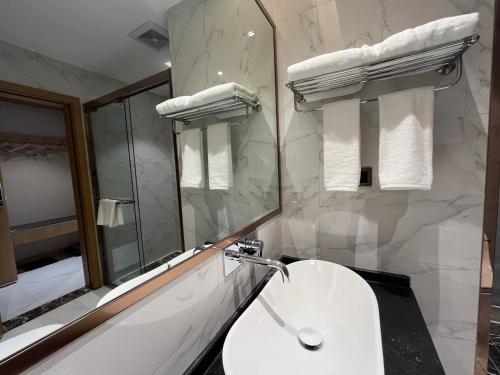 张家界Zhangjiajie lollipop Hotel的白色的浴室设有水槽和镜子