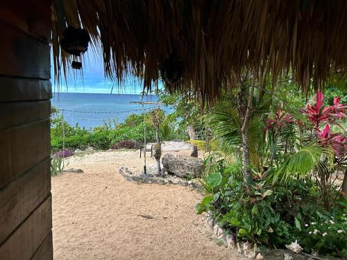 Little BayLittle Bay Bungalow的从草屋可欣赏到海滩景色