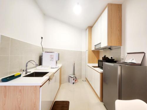 哥打京那巴鲁The Shore Kota Kinabalu City Centre by LW Suites的一间带水槽和冰箱的小厨房