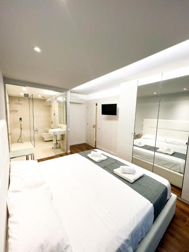 伊维萨镇Botafoch Luxury Room的一间带白色大床的卧室和一间浴室