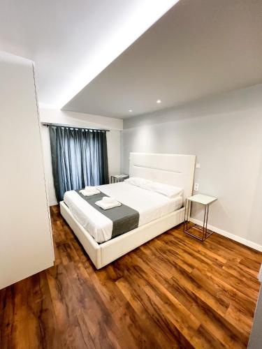 伊维萨镇Botafoch Luxury Room的卧室配有白色的床,铺有木地板